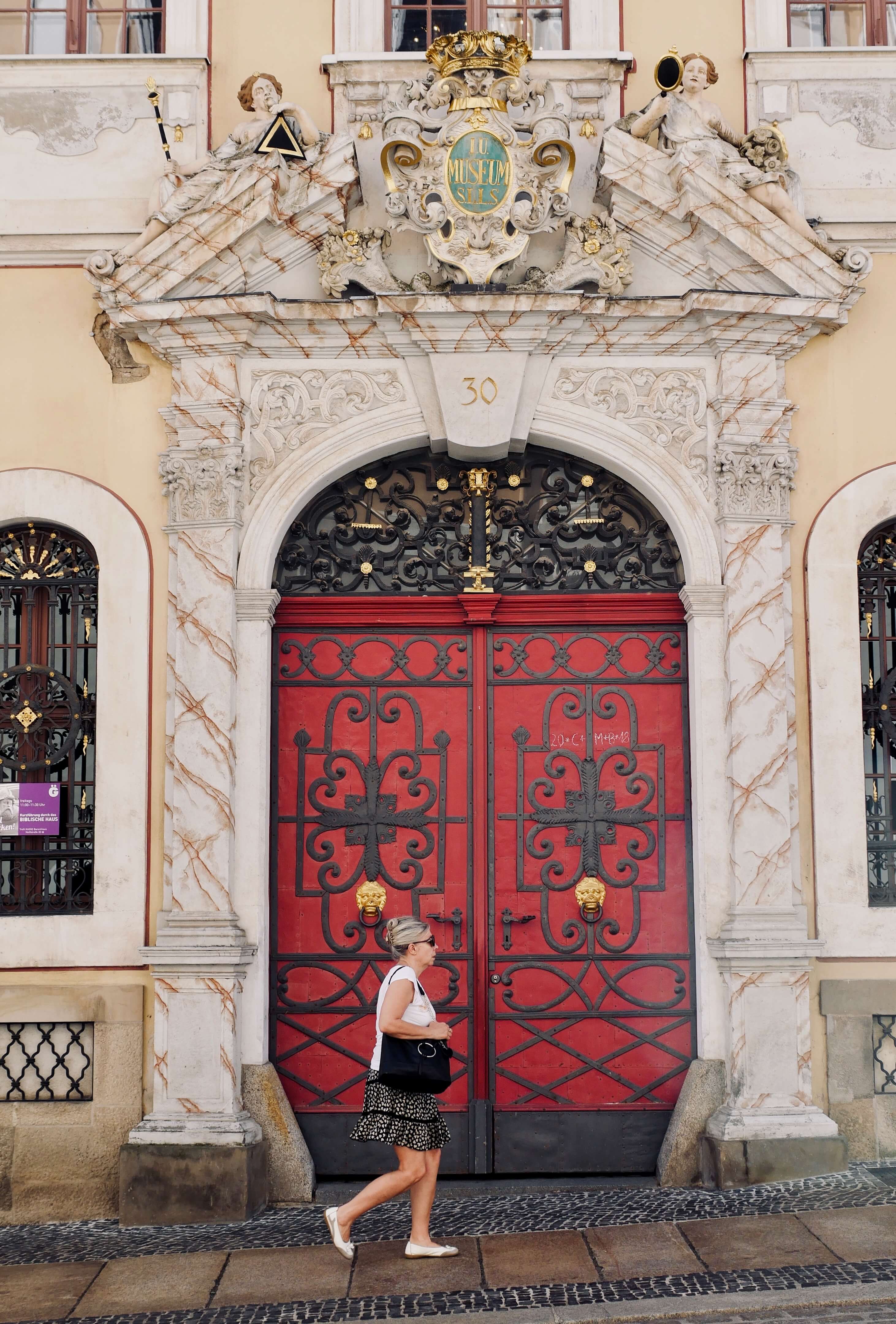 intricately carved beautiful red door with glorious marble frame