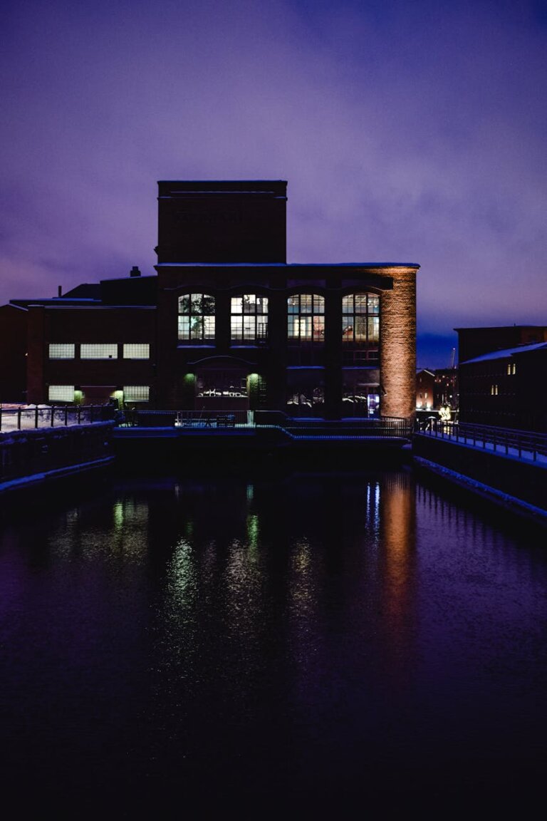 industrial building in city reflecting in the water at dusk