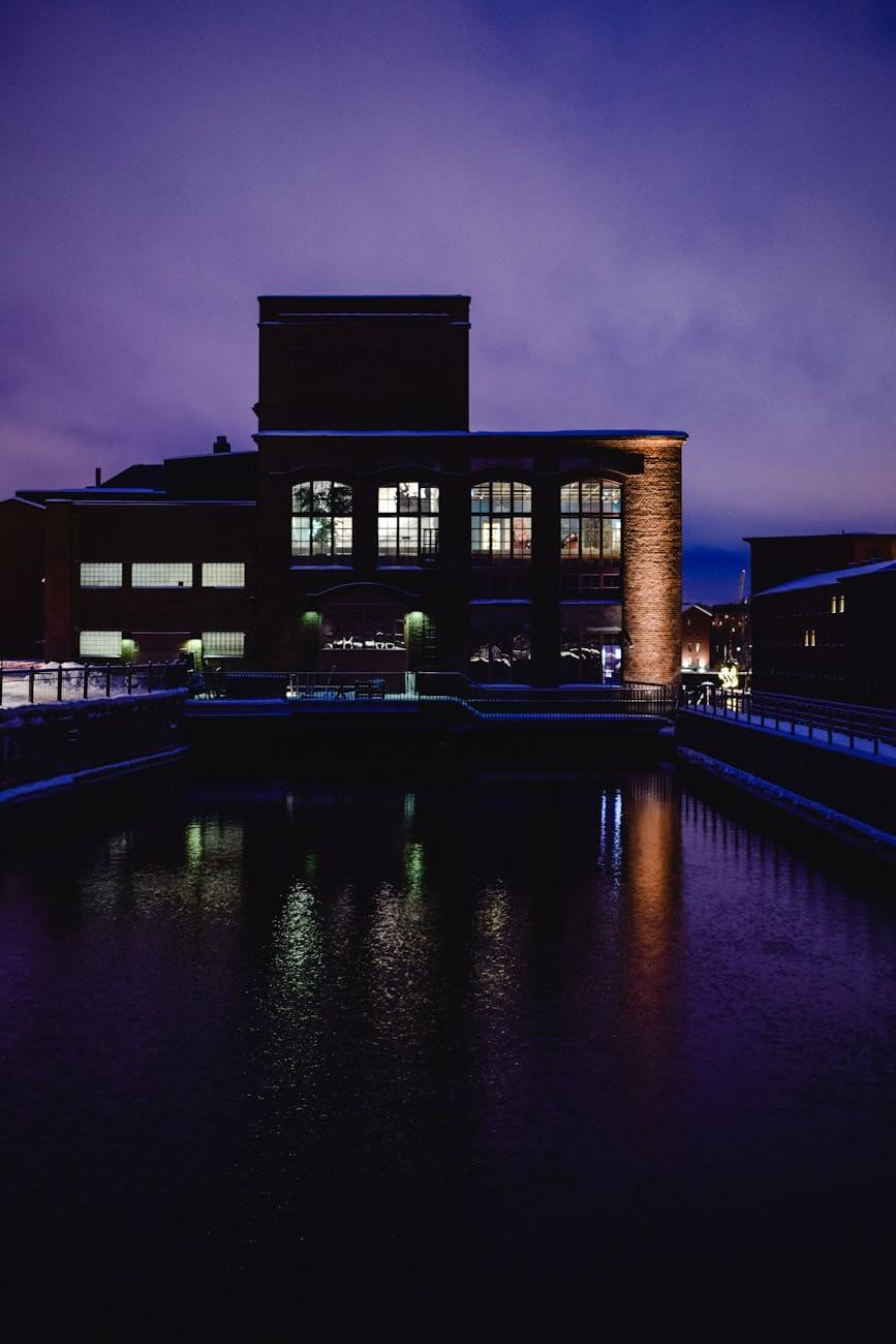 industrial building in city reflecting in the water at dusk